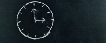 a chalk drawing of a clock face on a blackboard