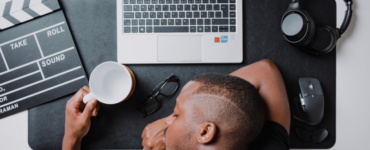 man sleeping on cluttered desk to show employee burnout signs